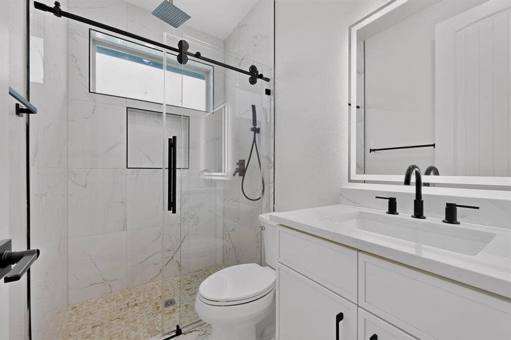 1672 Brookview Drive, Lancaster, TX 75146 Shower with a sliding glass door, white tiled walls, and a pebble floor