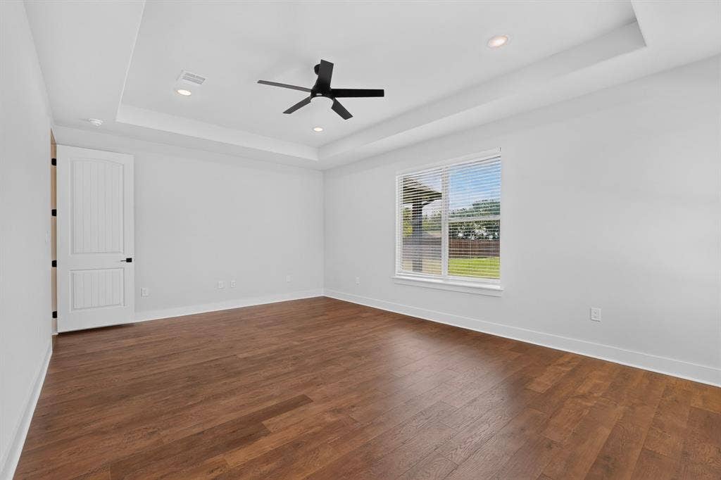 1672 Brookview Drive, Lancaster, TX 75146 Wood-finish flooring, white walls, and a tray ceiling with recessed lighting