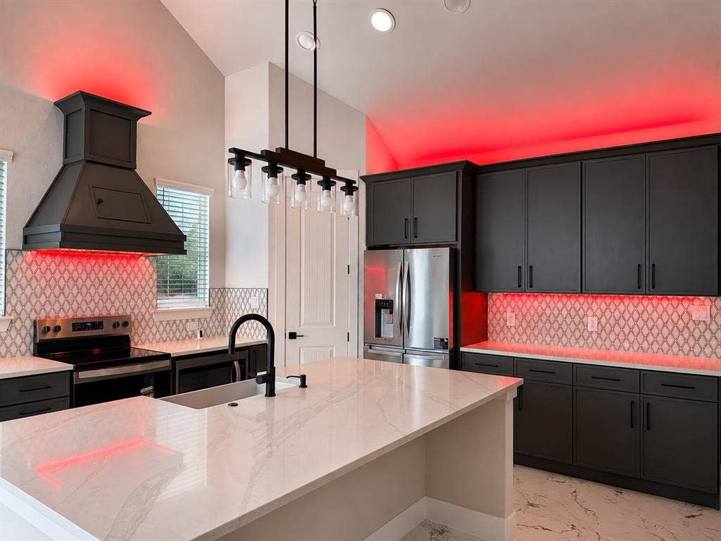 1672 Brookview Drive, Lancaster, TX 75146 Gourmet kitchen featuring dark cabinetry, a built-in range hood, stainless steel appliances, and a mosaic tile backsplash