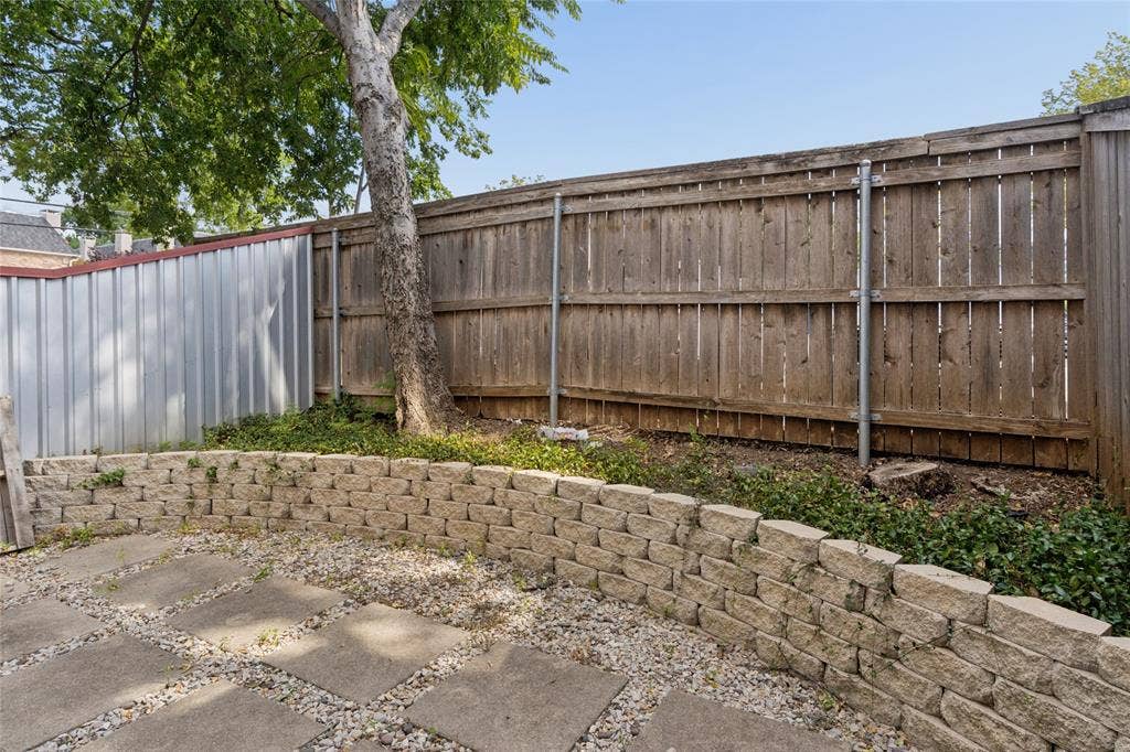2714 Shelby Avenue, Dallas, TX 75219 Paved patio area featuring large square pavers, gravel accents, and a stone retaining wall