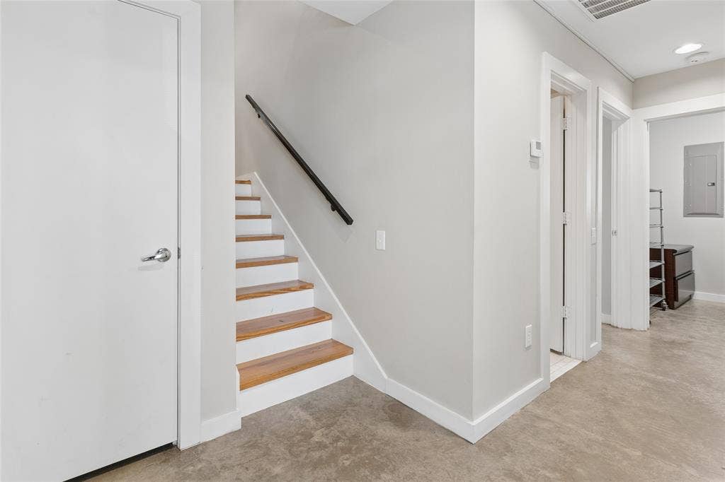 2714 Shelby Avenue, Dallas, TX 75219 Staircase with wood-finish treads and a black handrail