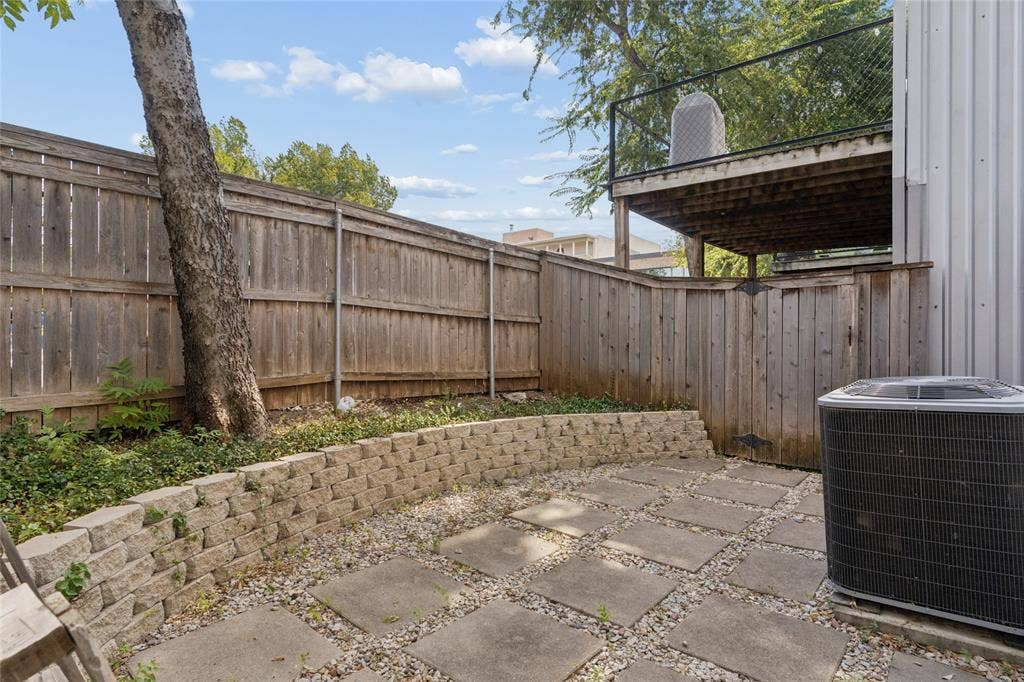 2714 Shelby Avenue, Dallas, TX 75219 Private outdoor space featuring stone paver patio and retaining wall, wood fencing, and a permanent elevated deck structure