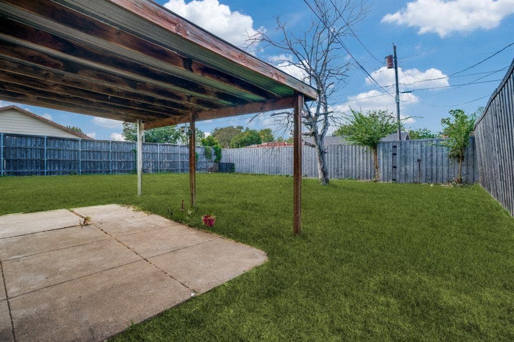 1412 E Park Boulevard, Plano, TX 75074 Expansive backyard with a covered patio, concrete slab, and wood privacy fencing