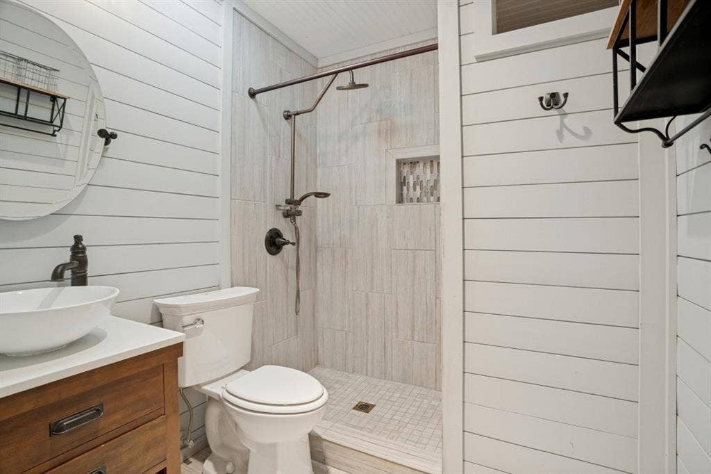 1412 E Park Boulevard, Plano, TX 75074 White shiplap walls complement the wood-finish vanity with a vessel sink