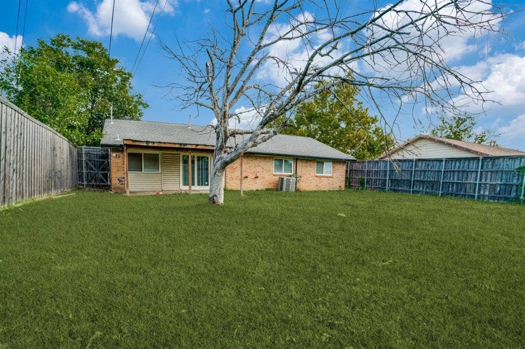 1412 E Park Boulevard, Plano, TX 75074 Expansive grassy yard with wood fencing and a brick exterior