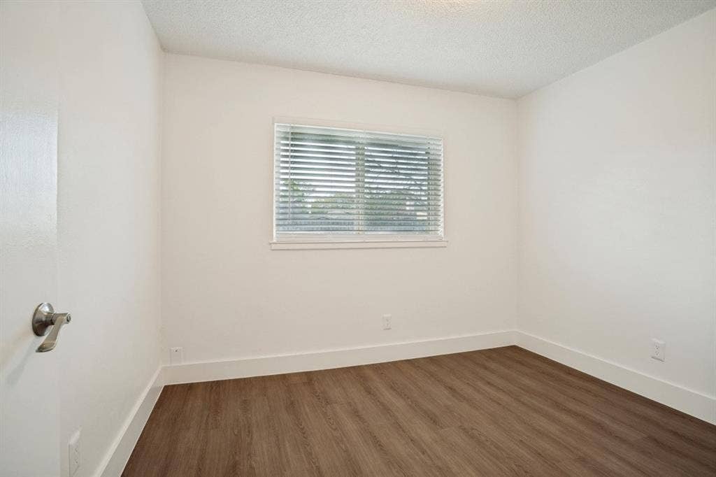 1412 E Park Boulevard, Plano, TX 75074 Wood-finish flooring, white wall paint, window with blinds, white trim, and a ceiling light fixture