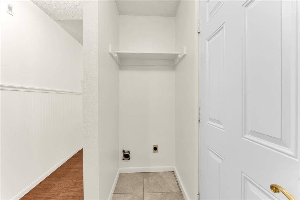 4626 Lexington Street, Bellmead, TX 76705 Laundry area with tile flooring, wall-mounted shelving, and plumbing hookups