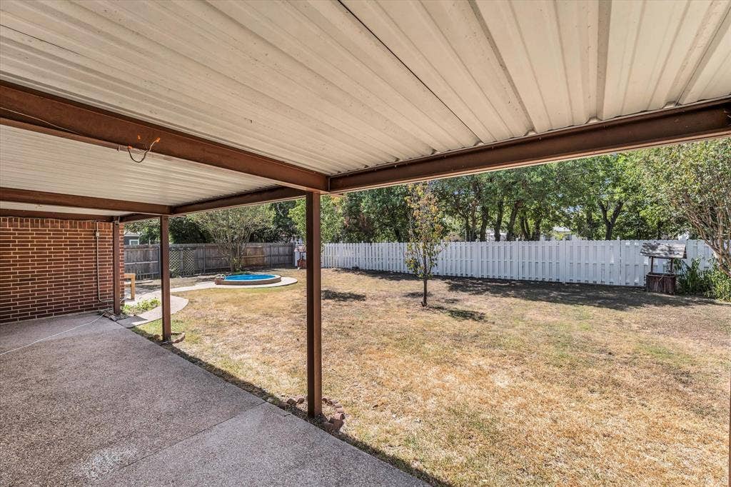 4626 Lexington Street, Bellmead, TX 76705 Covered patio with concrete flooring, brick exterior wall, and white picket fencing