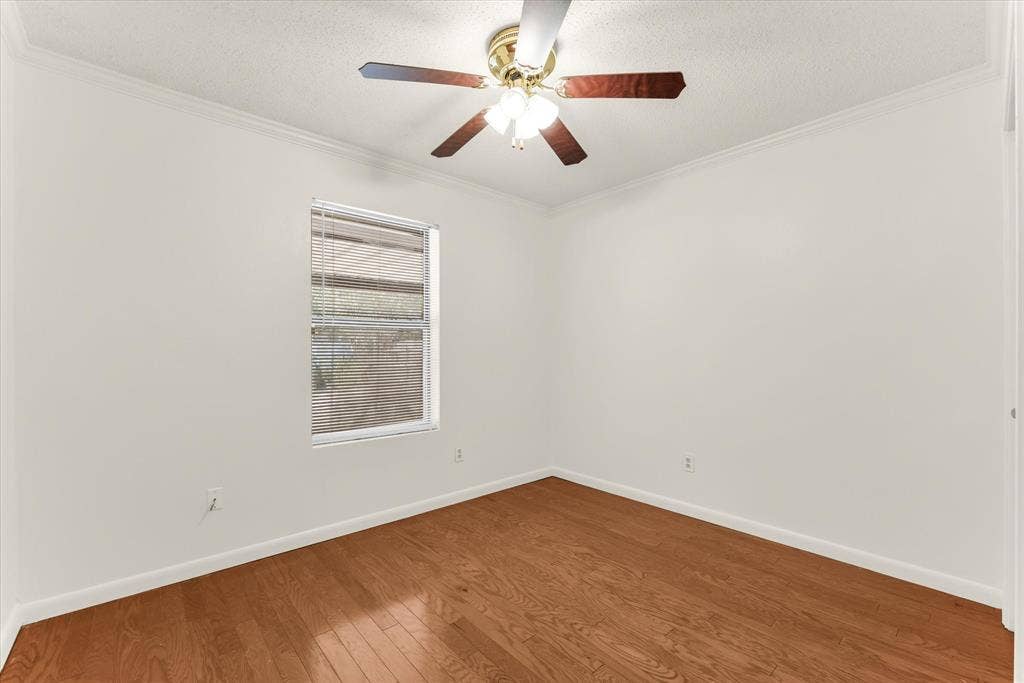 4626 Lexington Street, Bellmead, TX 76705 Hardwood flooring, crown molding, window with blinds, ceiling fan with light fixture, and white painted walls