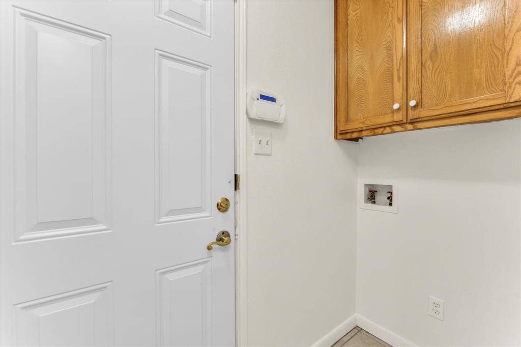 4626 Lexington Street, Bellmead, TX 76705 Utility area with light wood-finish cabinetry, white walls, and tiled flooring