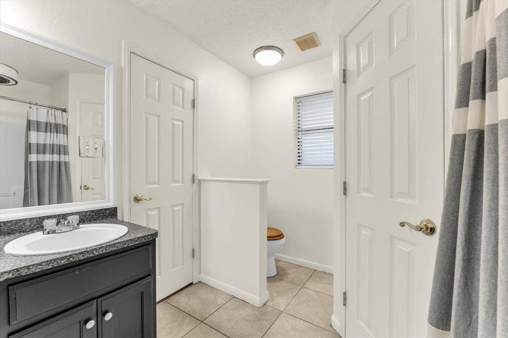 4626 Lexington Street, Bellmead, TX 76705 Vanity with an oval sink, dark countertop, and mirror