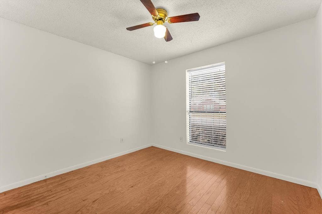 4626 Lexington Street, Bellmead, TX 76705 Wood-finish flooring, ceiling fan with integrated lighting, and a window with horizontal blinds