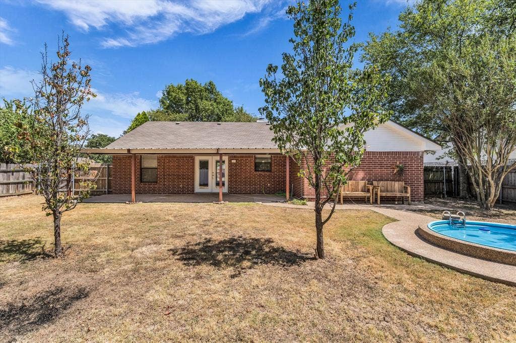 4626 Lexington Street, Bellmead, TX 76705 Brick exterior with covered patio, fenced yard, and an in-ground swimming pool