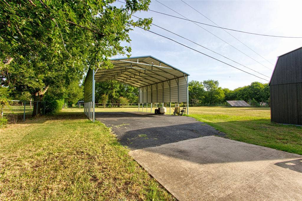 View Of 30' x 40' Tall RV Parking w50amp Power & Asphalt Drive From Concrete To Under Cover