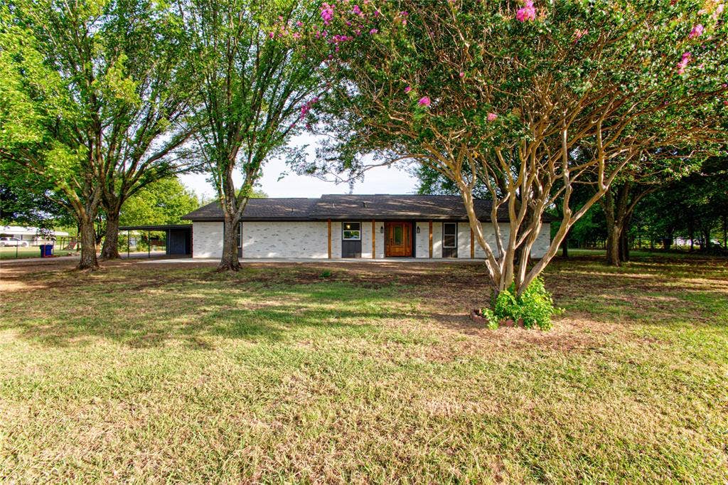 Full Front View Inside the Property Fence & Through the Mature Trees.