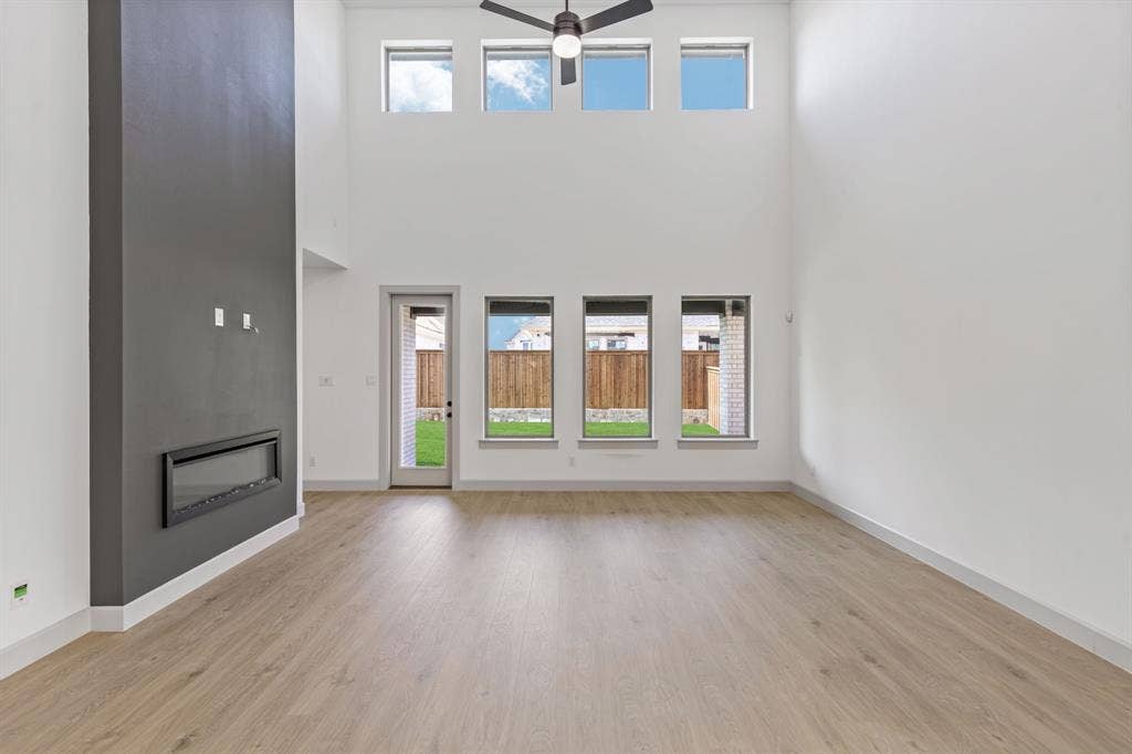 2616 Radiant Way, Celina, TX 75009 Featuring a striking fireplace and dual stacked wall of windows, this spacious family room is the ideal place to host the entire family!