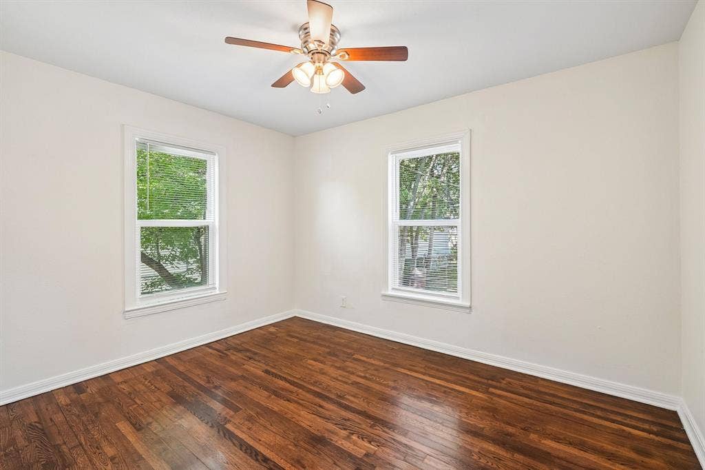 5012 Pamela Drive, Fort Worth, TX 76116 Hardwood flooring, white walls, two windows, and a ceiling fan with integrated lighting