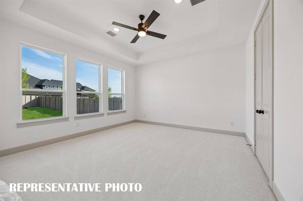 2629 Radiant Way, Celina, TX 75009 Featuring a wall of windows, high ceilings and plush carpeting, this dreamy owner's suite is the perfect place to relax and unwind at the end of the day. REPRESENTATIVE PHOTO