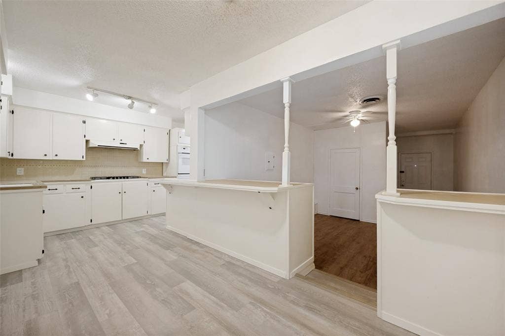 3214 Avon Street, Denton, TX 76209 Kitchen featuring white cabinetry, light-toned countertops, and track lighting