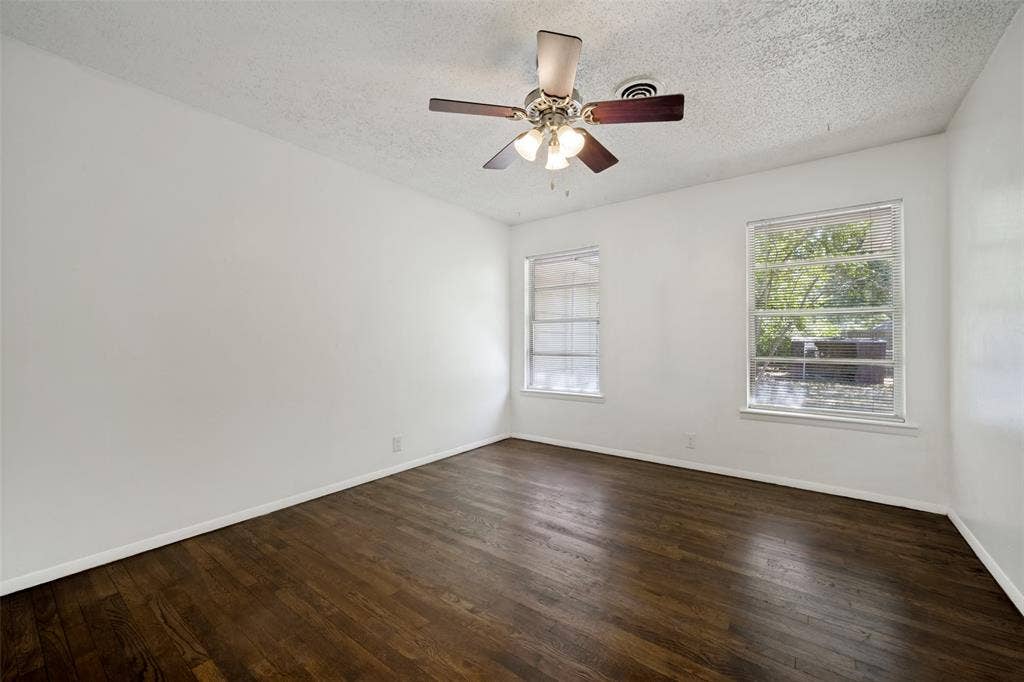 3214 Avon Street, Denton, TX 76209 Hardwood flooring, two windows, ceiling fan with light fixture, and white walls