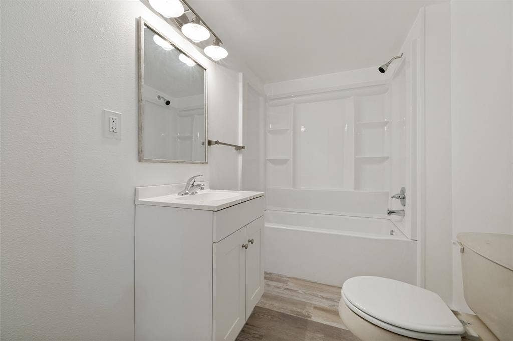 3214 Avon Street, Denton, TX 76209 White vanity with integrated sink, chrome faucet, and overhead bar lighting