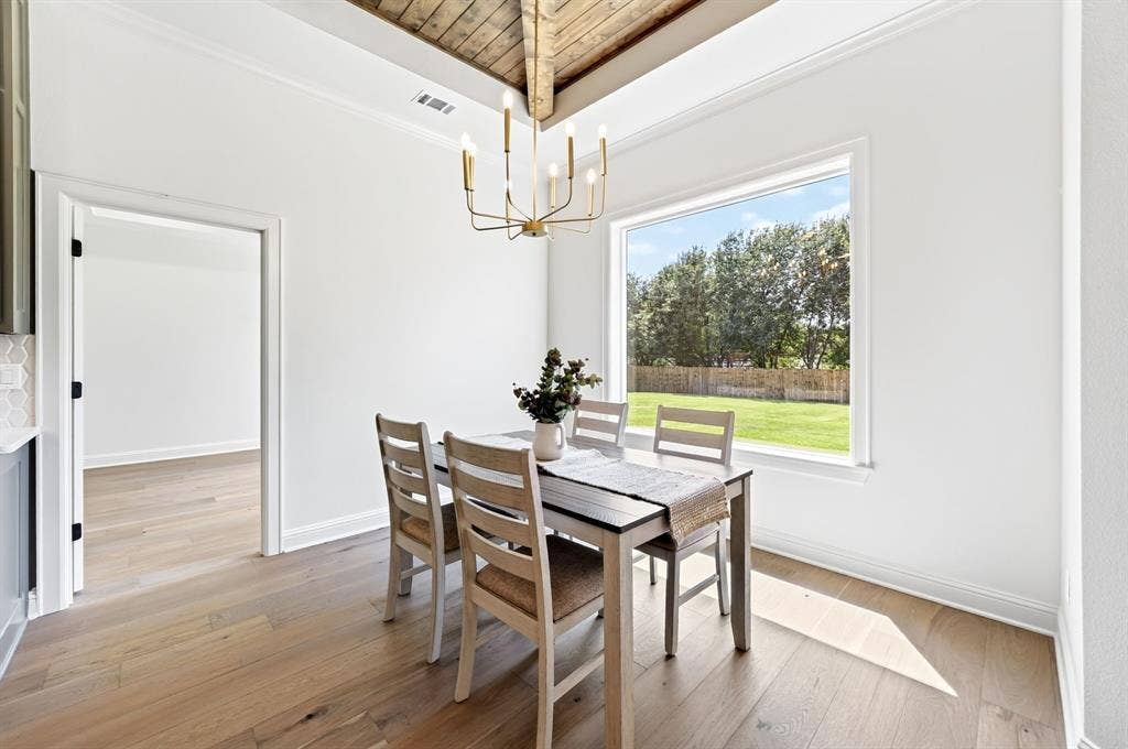 302 Grace Lane, Athens, TX 75751 Dining area featuring decorative wooden beams, ample natural lighting with views of the backyard.