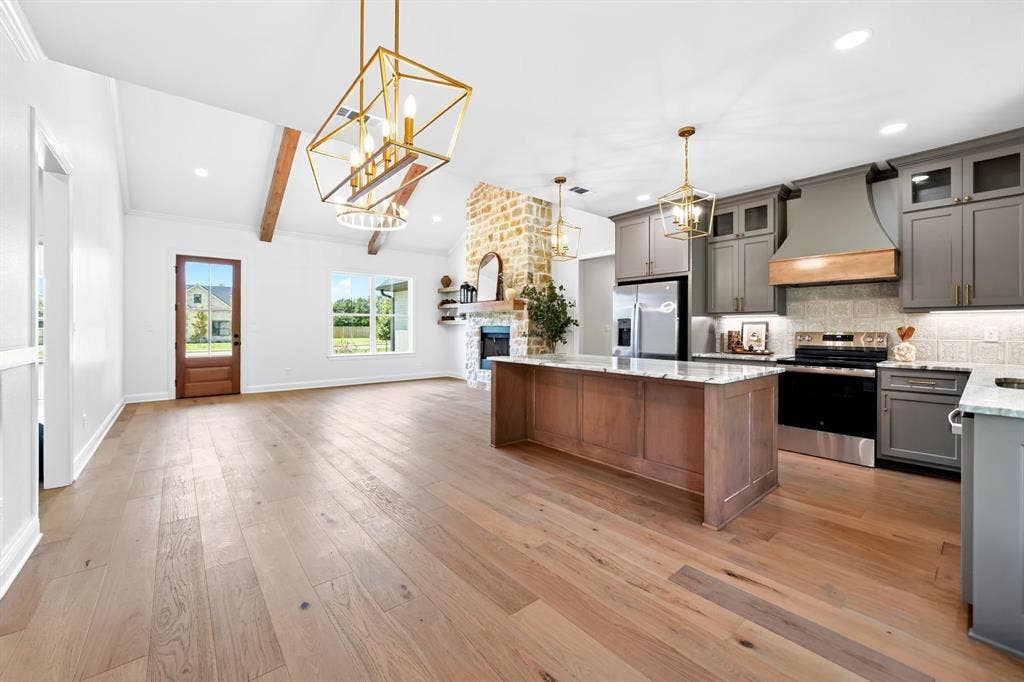 305 Grace Lane, Athens, TX 75751 Open-concept living area with wood-finish flooring, exposed ceiling beams, and a stone fireplace