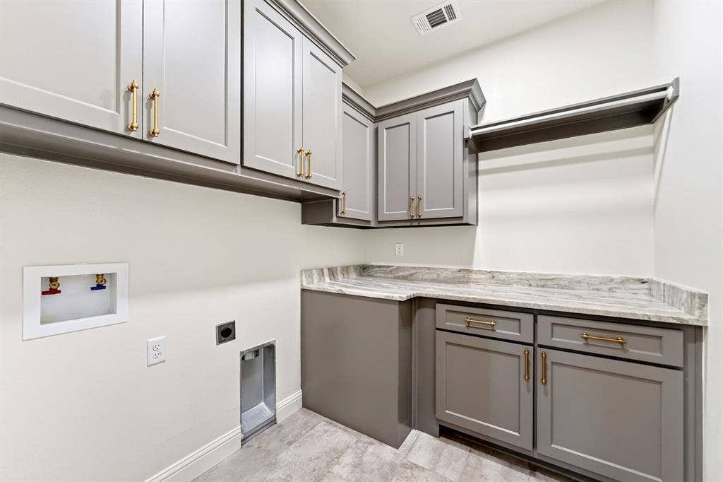 305 Grace Lane, Athens, TX 75751 Shaker-style cabinetry with gold-tone hardware, a light-toned countertop, and integrated hanging rod