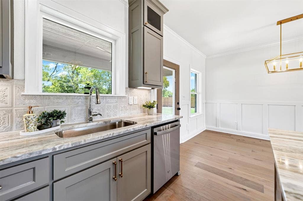 305 Grace Lane, Athens, TX 75751 Kitchen featuring shaker-style cabinetry, a stainless steel sink, and a patterned tile backsplash