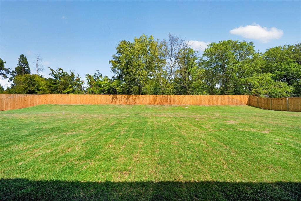 305 Grace Lane, Athens, TX 75751 Expansive green lawn with a wood privacy fence and mature perimeter trees