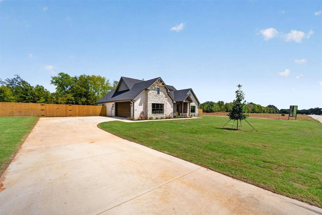 305 Grace Lane, Athens, TX 75751 Stone and brick exterior with dark trim accents, covered entry, and an attached garage