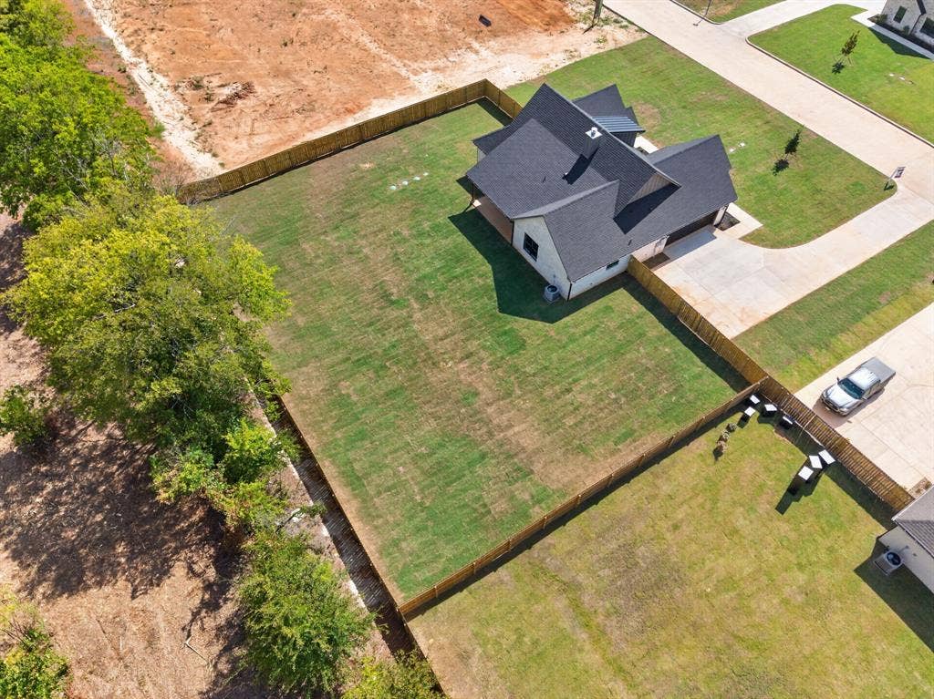 305 Grace Lane, Athens, TX 75751 New construction residence featuring a dark shingle roof, light-colored exterior, and an expansive lawn
