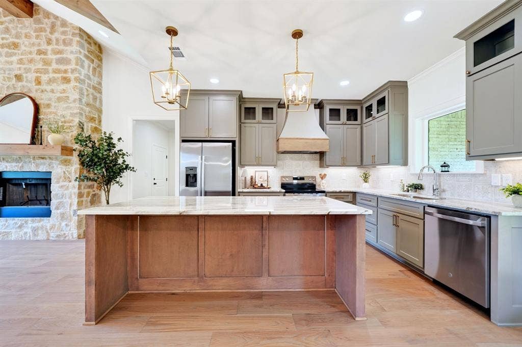 305 Grace Lane, Athens, TX 75751 Kitchen featuring a large central island with a light-toned countertop, light wood-finish flooring, recessed lighting, and stainless steel appliances