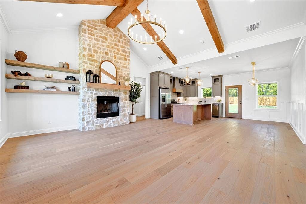 305 Grace Lane, Athens, TX 75751 Spacious open-concept living area featuring a stone fireplace, wood-finish flooring, and vaulted ceilings with exposed wood beams