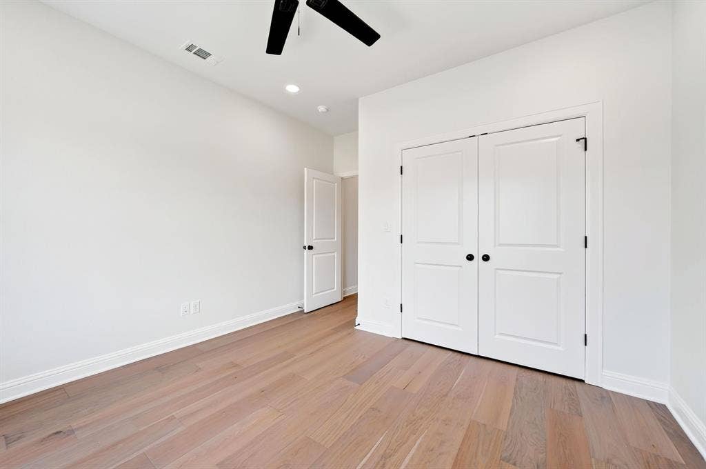 305 Grace Lane, Athens, TX 75751 Wood-finish flooring, white walls, white paneled doors, matte black door hardware, and a ceiling-mounted fan