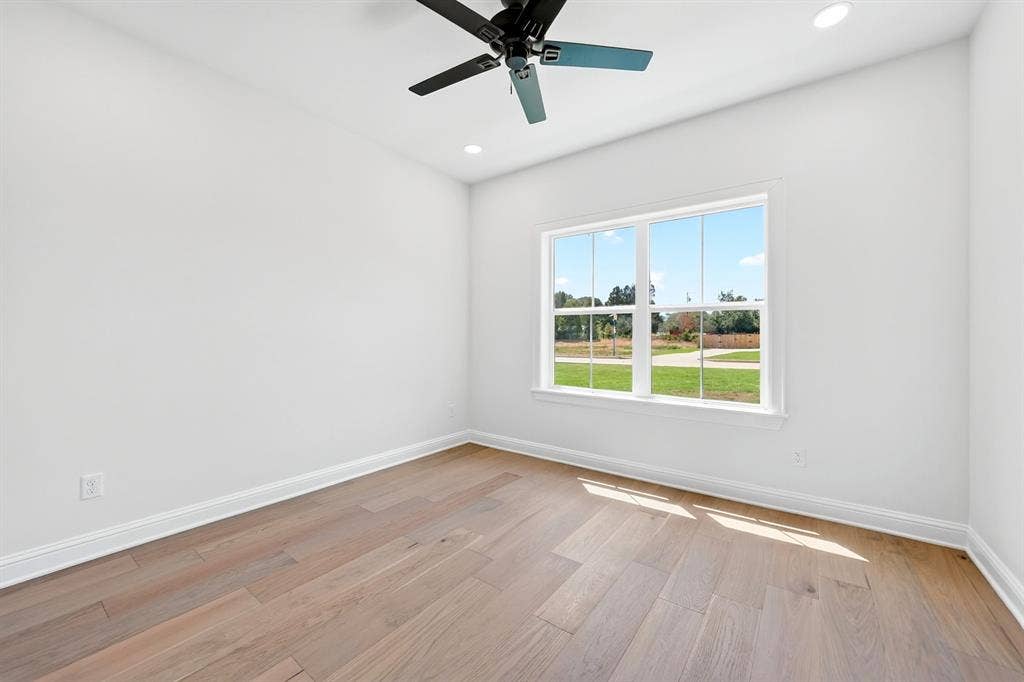 305 Grace Lane, Athens, TX 75751 Neutral white wall finishes, wood-finish flooring, recessed lighting, and a ceiling fan with integrated lighting