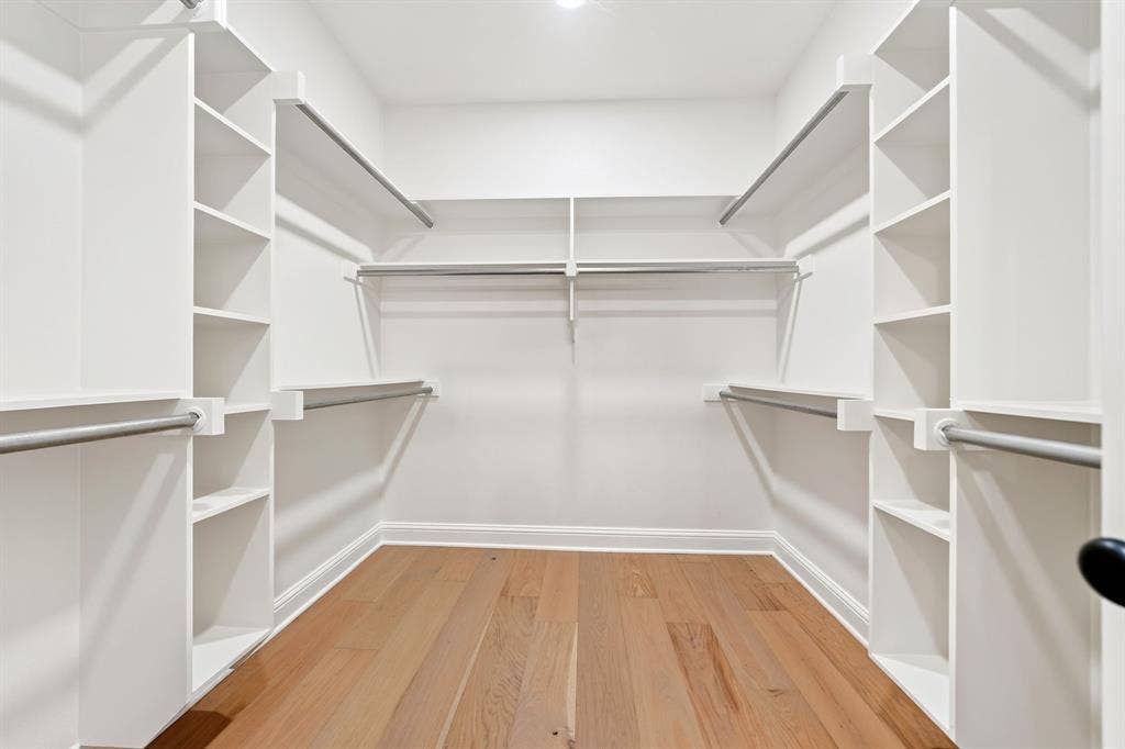 305 Grace Lane, Athens, TX 75751 Custom closet system featuring built-in shelving, multiple hanging rods, and wood-finish flooring