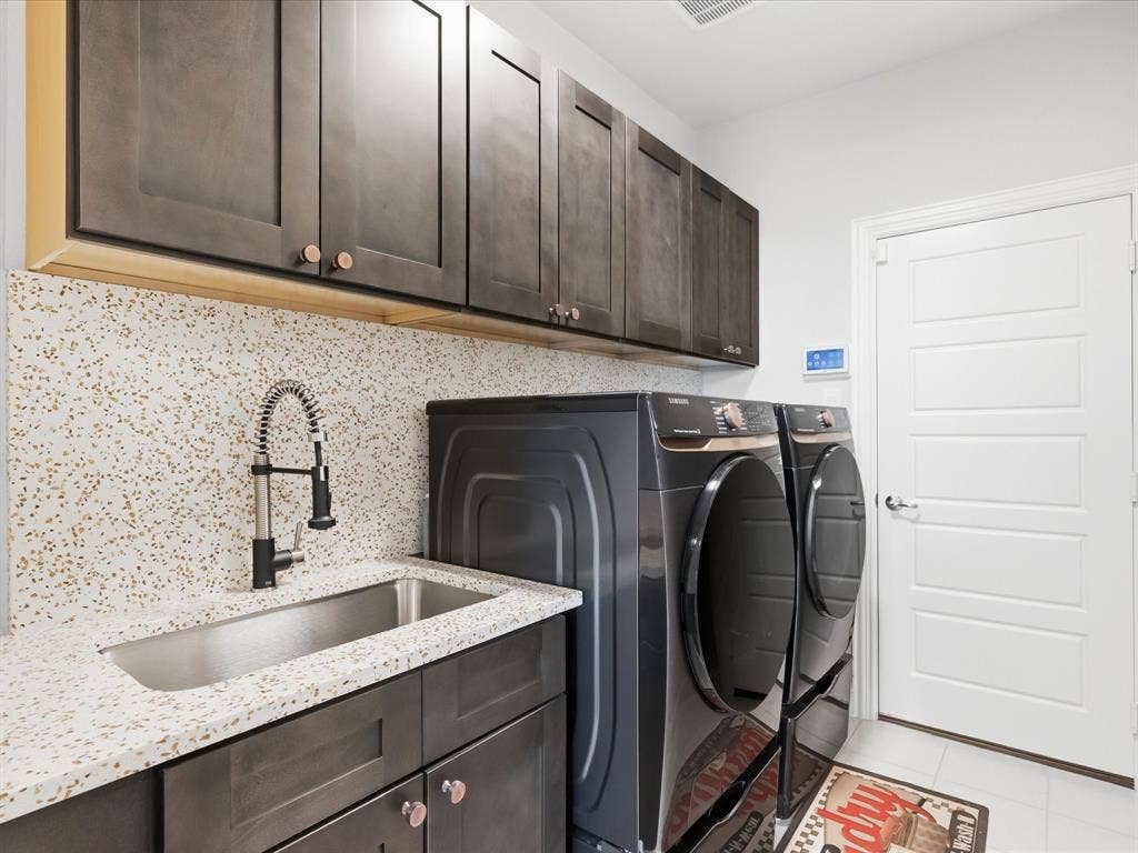 3505 Wycliff Avenue, McKinney, TX 75071 Built-in upper and lower cabinetry, speckled solid surface countertop, stainless steel utility sink, and a modern gooseneck faucet