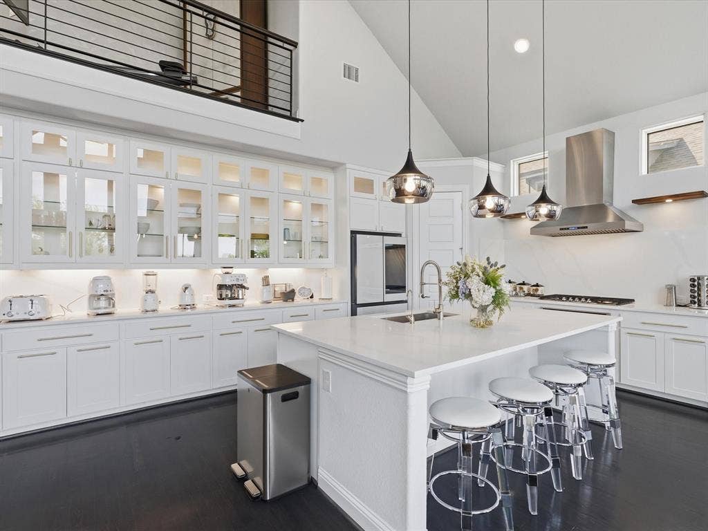 3505 Wycliff Avenue, McKinney, TX 75071 Gourmet kitchen with an expansive island, white cabinetry, integrated stainless steel appliances, and dark wood-finish flooring