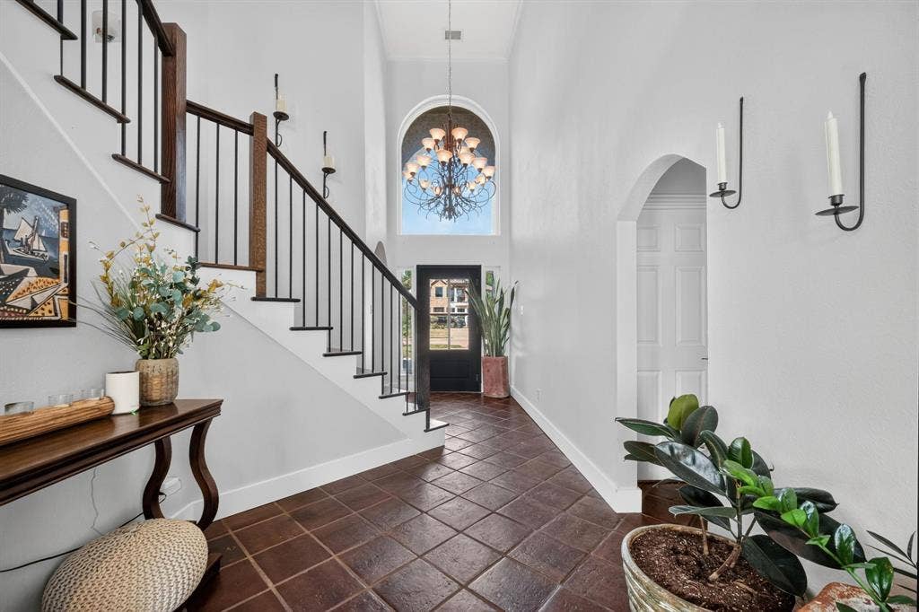 4016 Stone Haven Drive, Garland, TX 75043 Entryway featuring high ceilings, a grand staircase with wrought iron balusters, arched window, and beautiful flooring