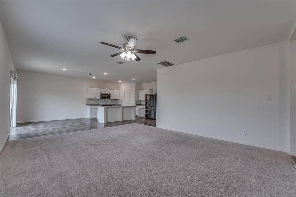 767 Camden Drive, Lavon, TX 75166 Spacious open-concept living area featuring soft gray carpeting, wood-finish flooring, a ceiling fan, and recessed lighting