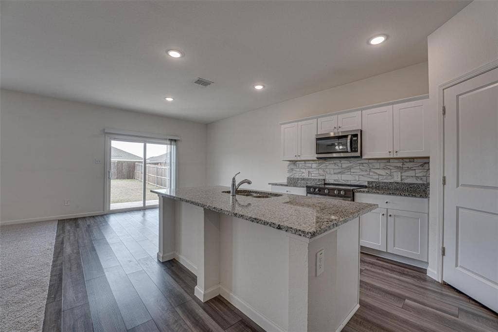 767 Camden Drive, Lavon, TX 75166 Open-concept living area with wood-finish flooring, recessed lighting, and a sliding glass door to the backyard