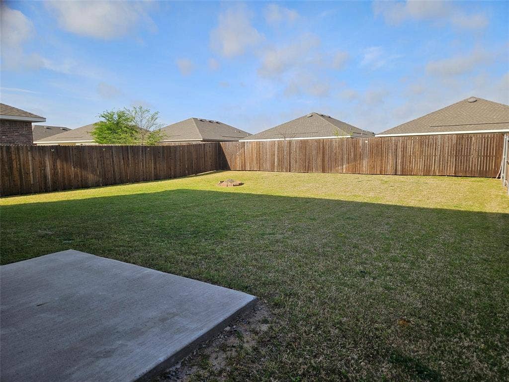 767 Camden Drive, Lavon, TX 75166 Expansive fenced backyard featuring a large concrete patio and mature wood privacy fencing