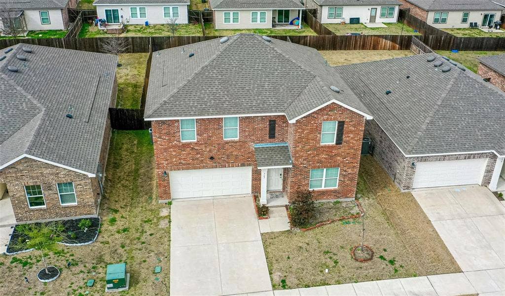 767 Camden Drive, Lavon, TX 75166 Two-story brick exterior with a two-car garage, concrete driveway, and gray shingle roof
