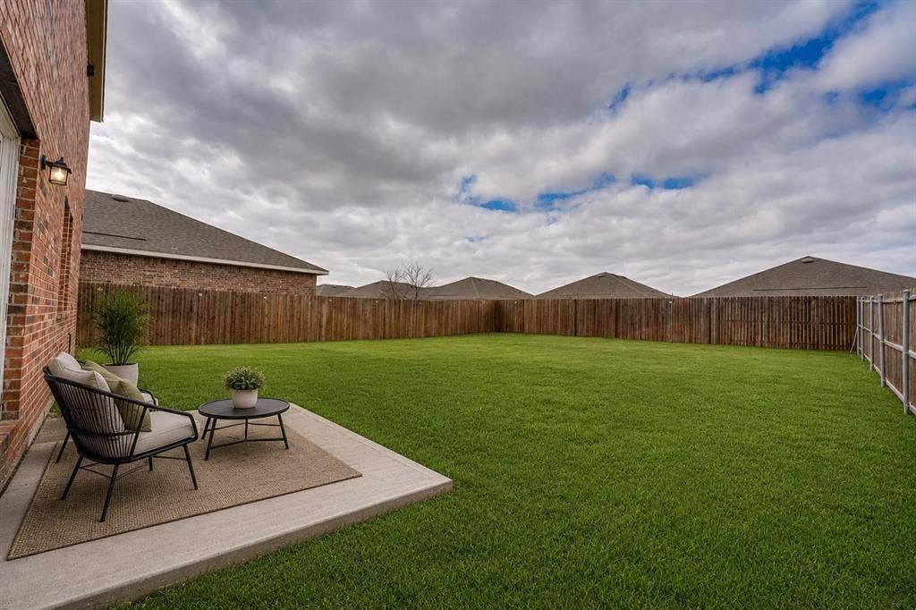 767 Camden Drive, Lavon, TX 75166 Expansive backyard featuring a manicured lawn, full privacy fencing, and a concrete patio