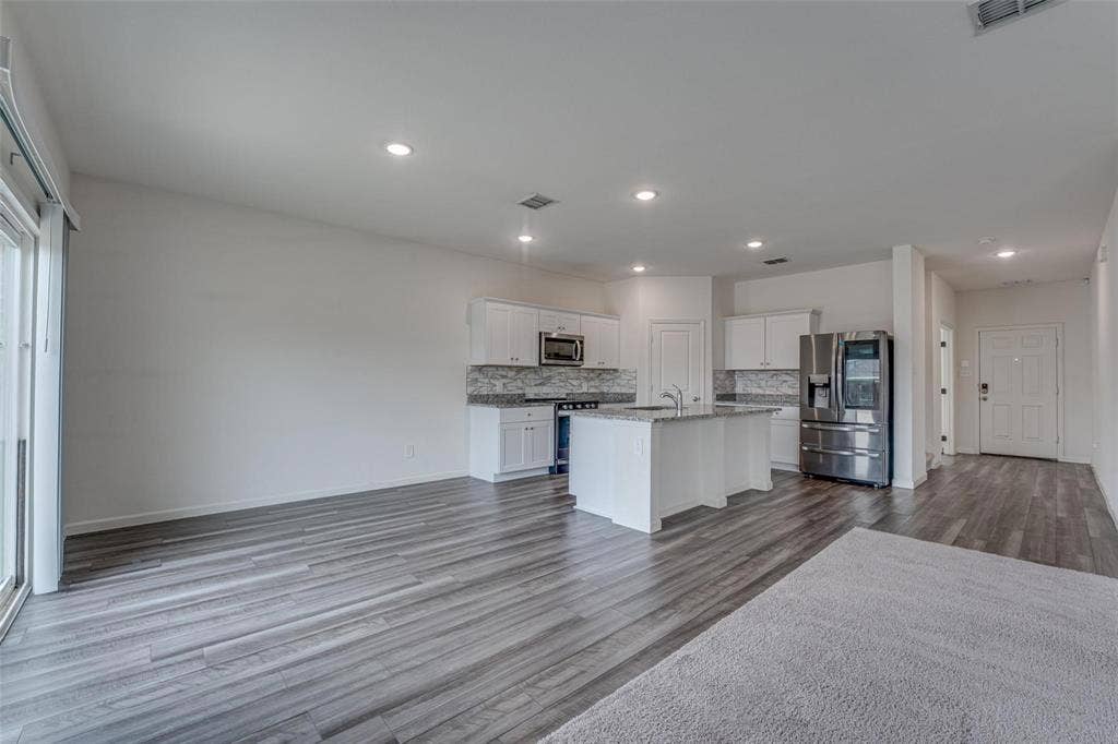 767 Camden Drive, Lavon, TX 75166 Open-concept living space featuring wood-finish flooring, recessed lighting, and a sliding glass door