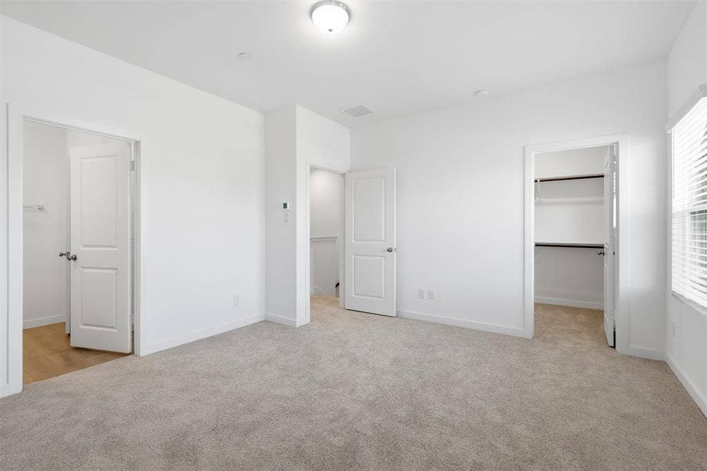 7621 Dakota, Watauga, TX 76148 Wall-to-wall carpeting, window with blinds, overhead lighting, and two separate closet spaces featuring built-in shelving