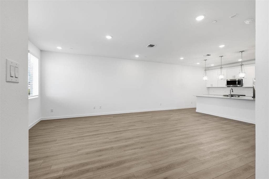 7621 Dakota, Watauga, TX 76148 Expansive open-concept space featuring wood-finish flooring, recessed lighting, and a kitchen island with pendant lighting
