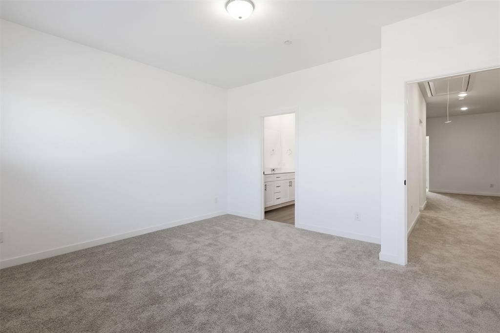 7621 Dakota, Watauga, TX 76148 Neutral-toned carpet flooring, white painted walls, ceiling-mounted light fixture, recessed lighting, and a bathroom entrance with a vanity
