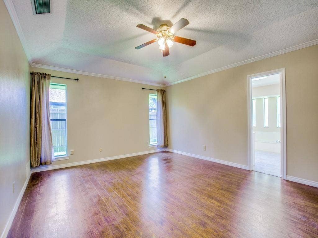 1103 Sundial Drive, Richardson, TX 75081 Tray ceiling with crown molding, wood-finish flooring, and a ceiling fan with integrated lighting